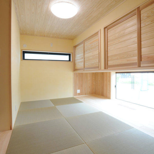 木製の吊り戸棚と窓のある畳の部屋