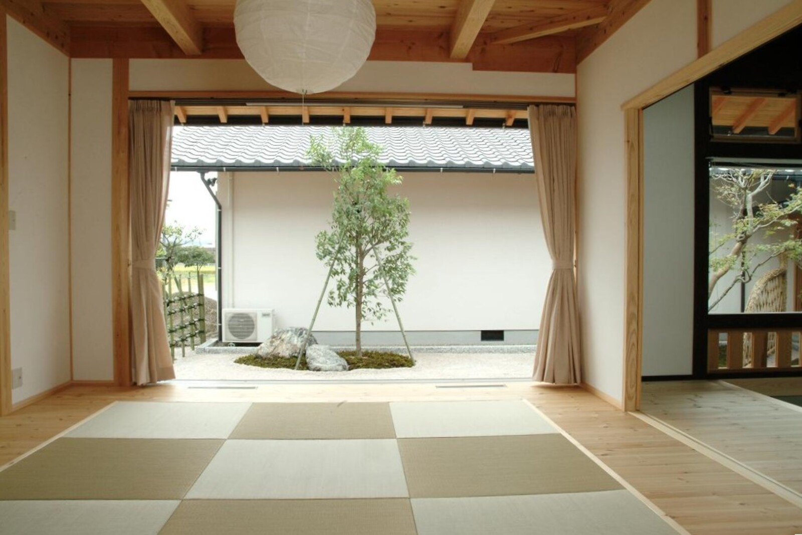 大きな窓から庭の木を眺められる畳の部屋